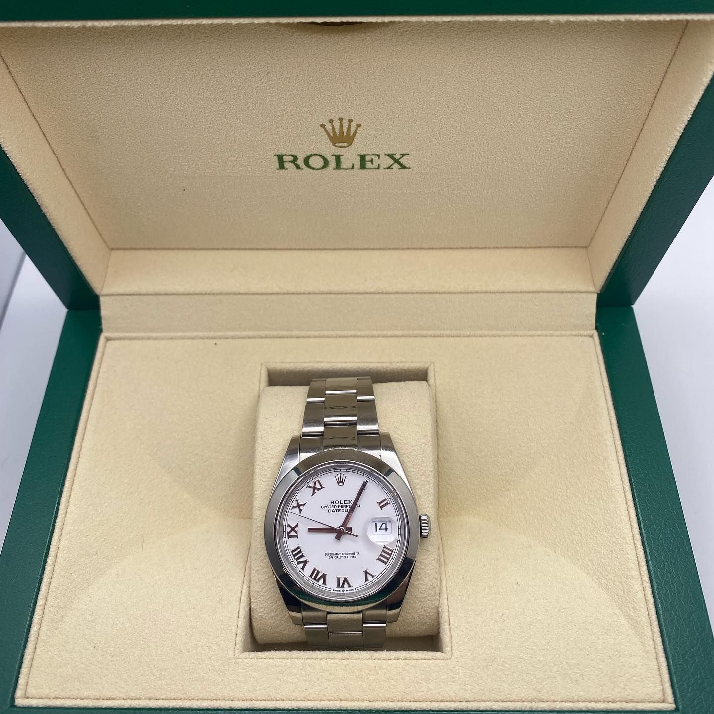 Rolex wristwatch in an open cream-colored presentation box