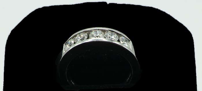 Silver ring with clear gemstones on a black background