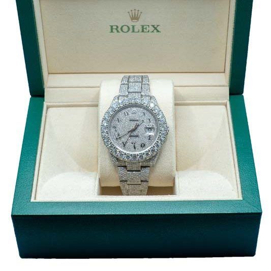 Silver Rolex watch in an open green box with a cream interior
