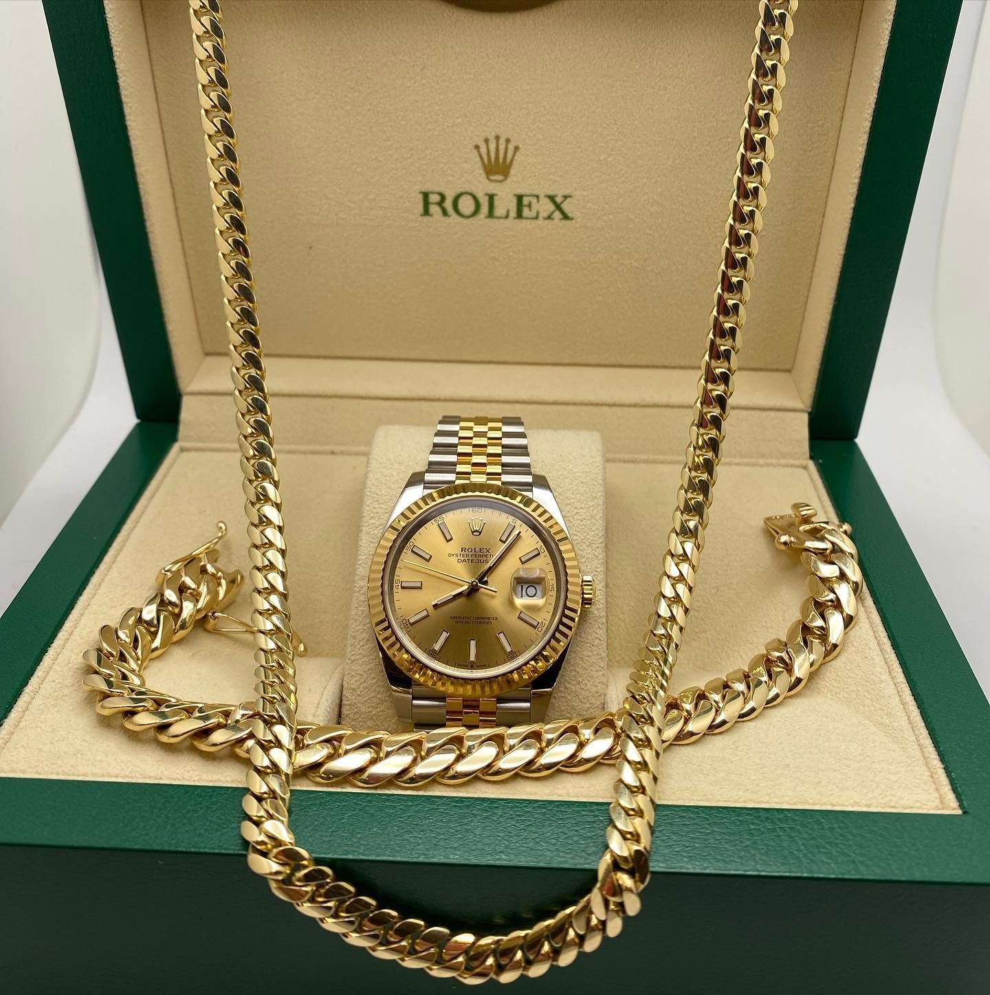 Gold Rolex watch on a thick gold chain in a green Rolex box