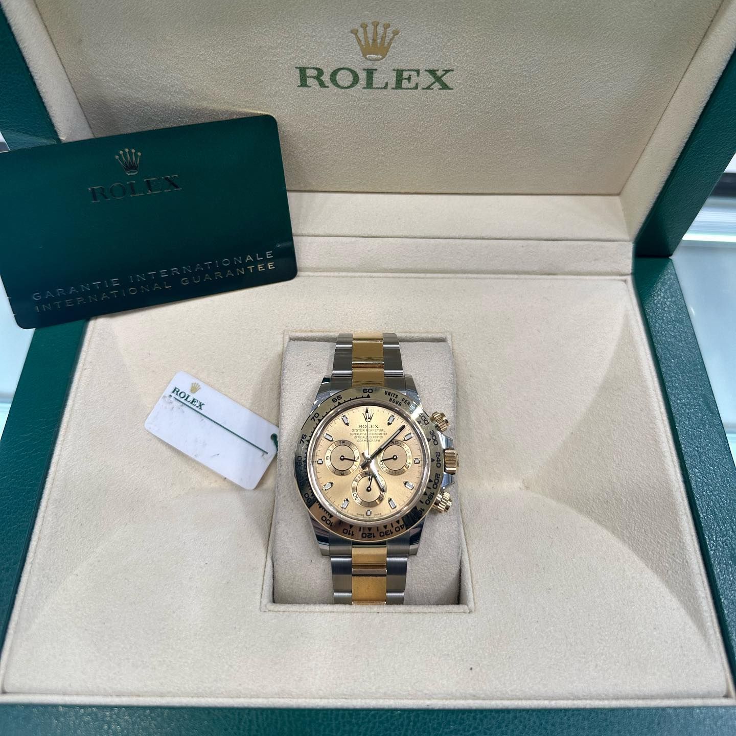Rolex watch in green presentation box with cream dial and gold accents
