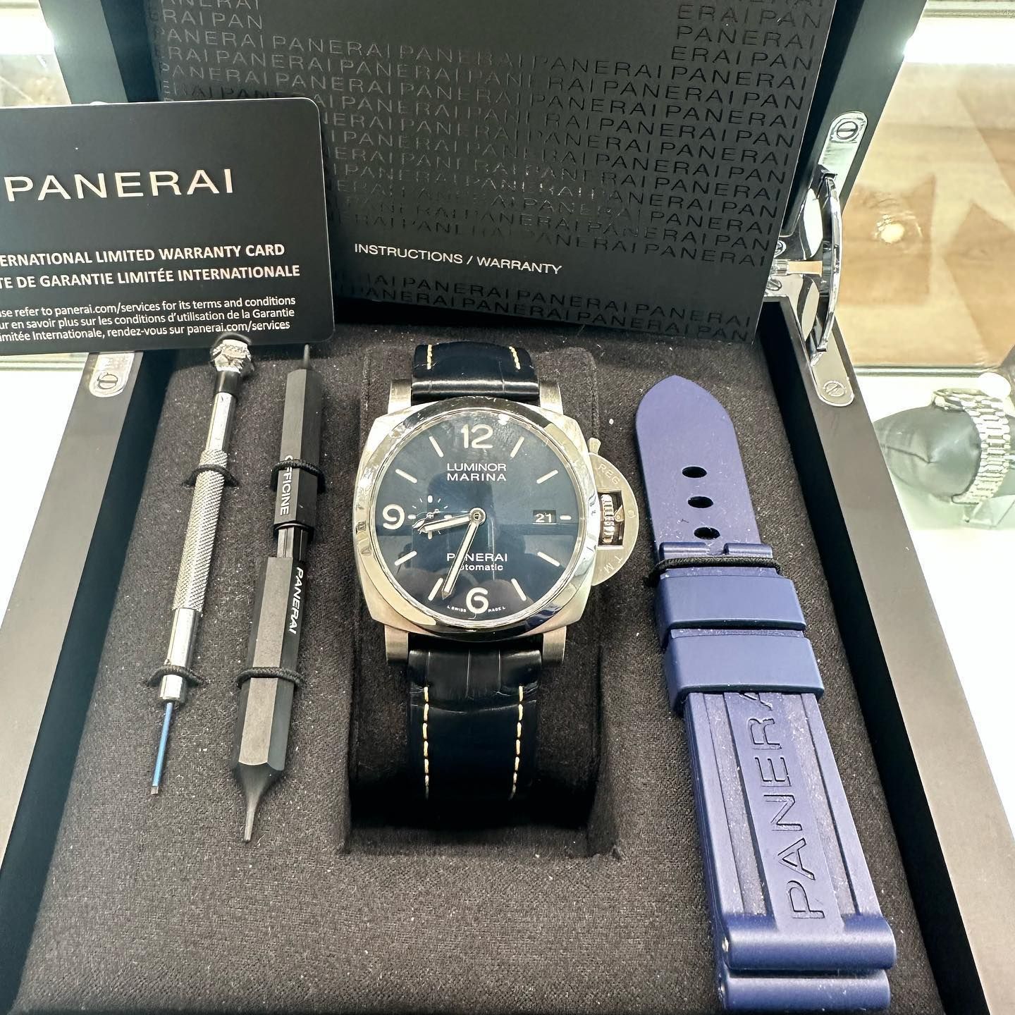 Panerai watch with blue strap, tools, and strap laid in an open presentation box