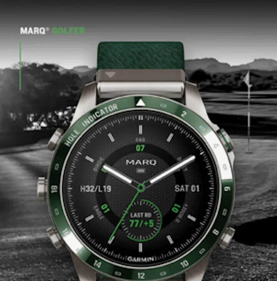 Green-and-silver Garmin MARQ watch with black dial and green strap against a grayscale landscape background