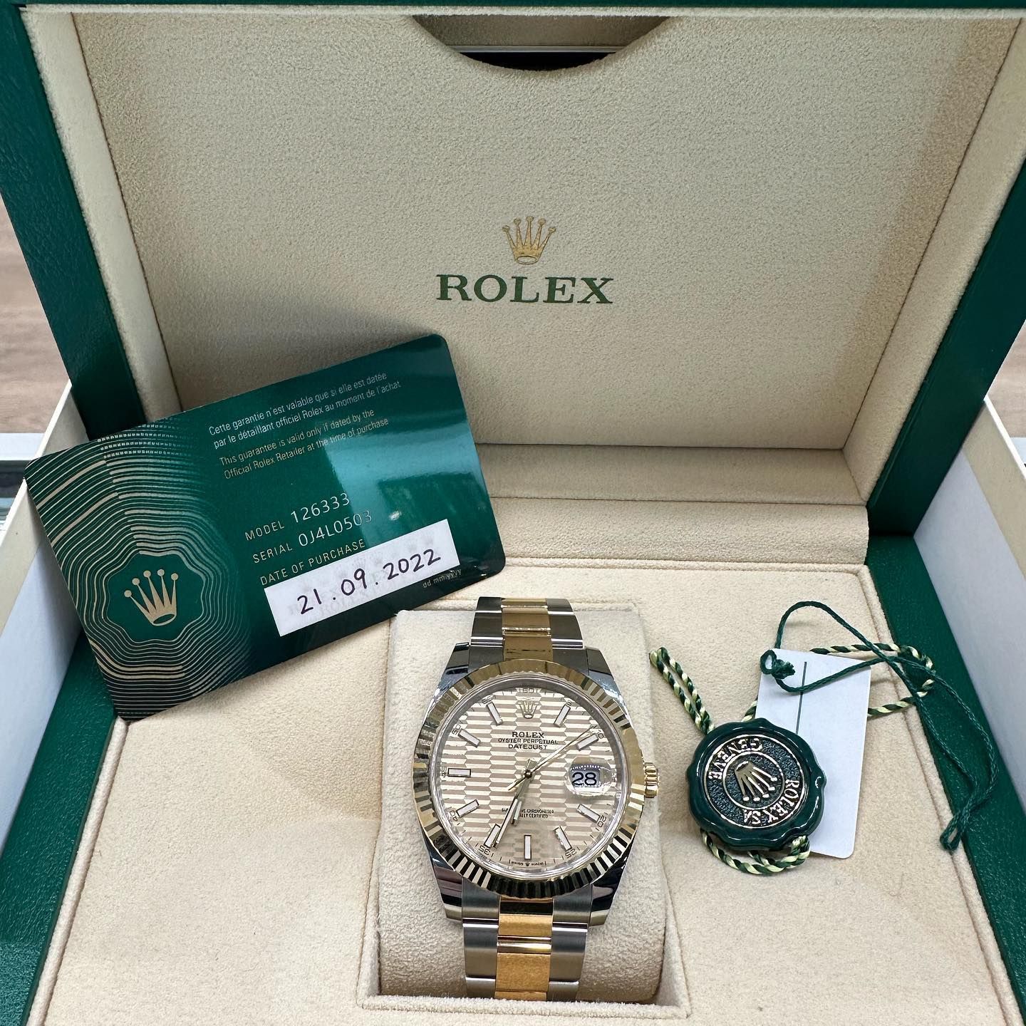 Rolex watch set in box with tags and green/steel bracelet, plus matching pendant and card