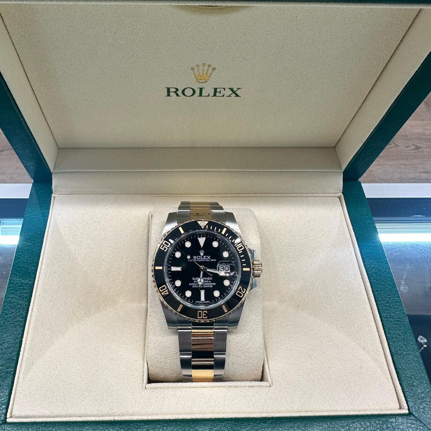 Rolex watch with black dial in a cream display box