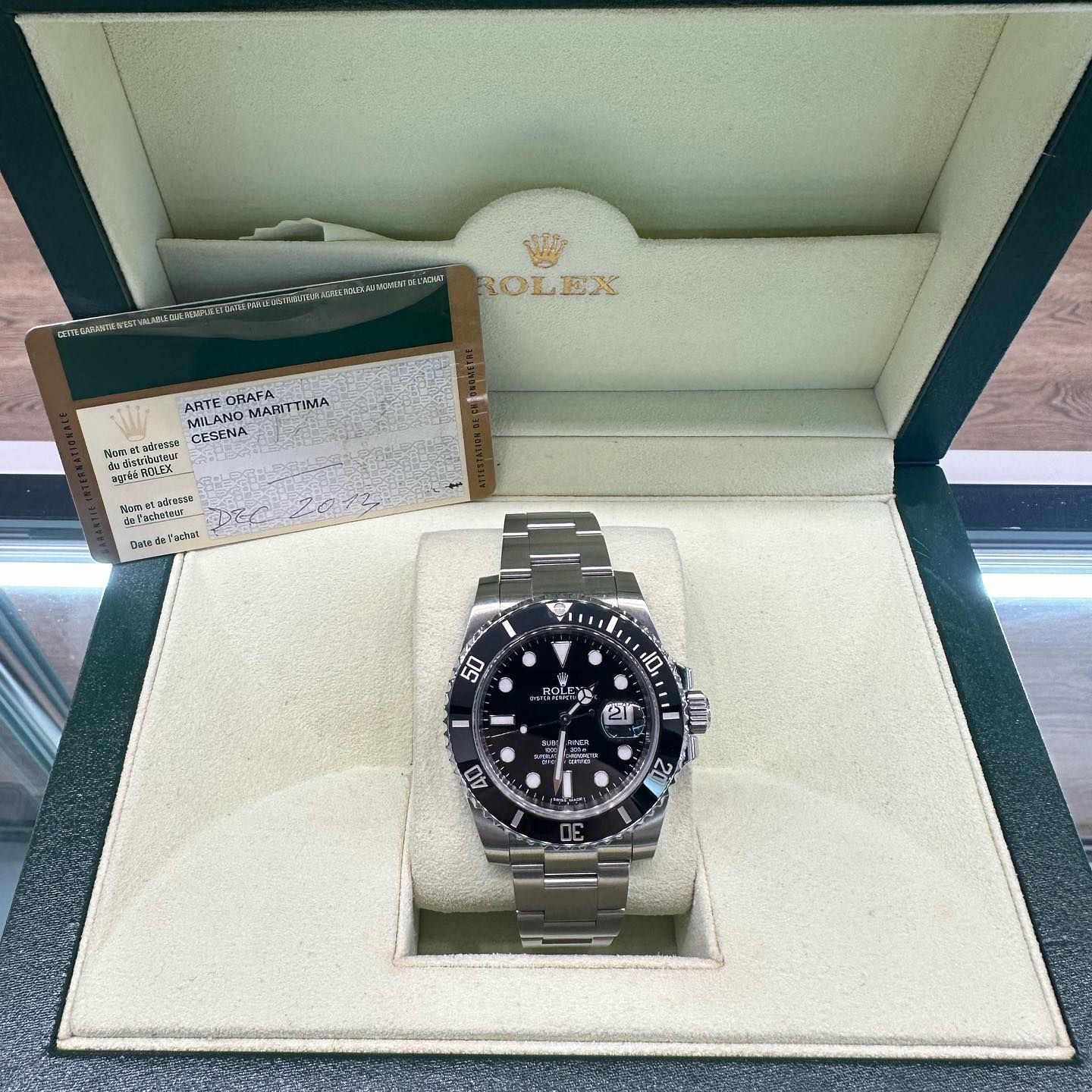 Rolex watch in an open presentation box with warranty cards and tags