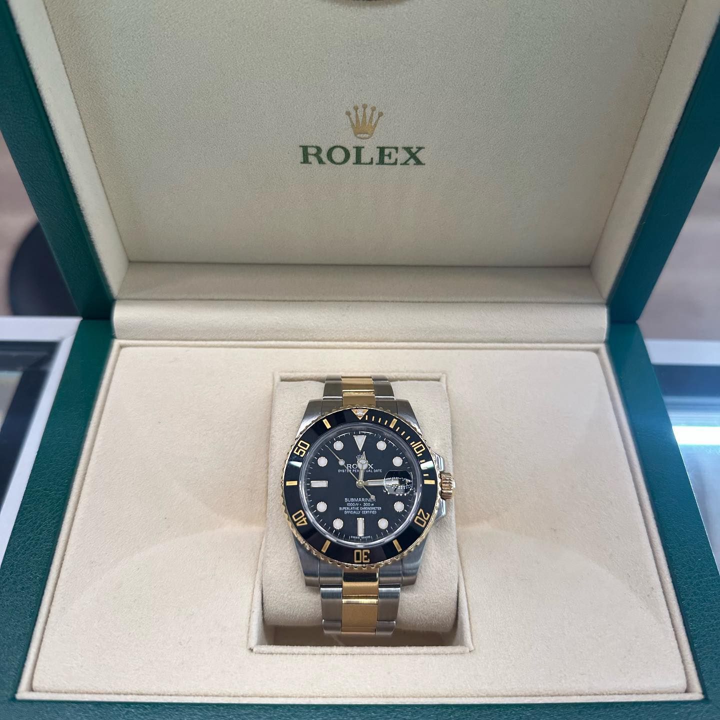 Rolex watch displayed in an open green presentation box