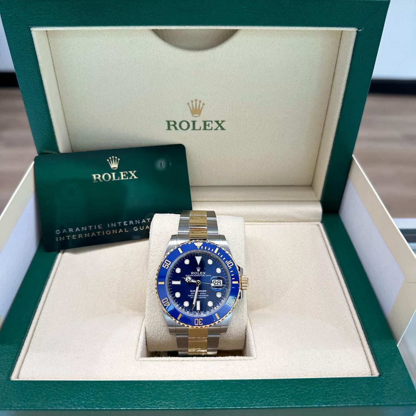 Rolex watch with blue dial in a green and cream presentation box