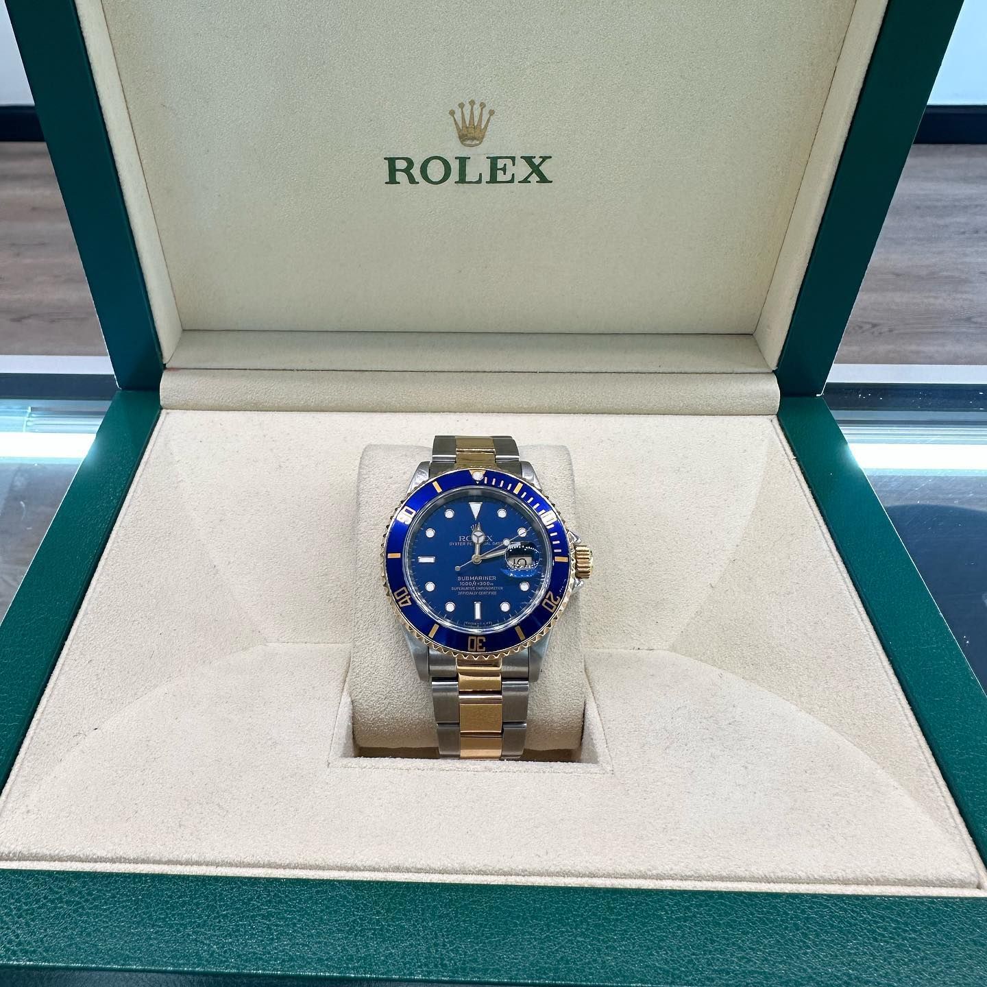 Rolex watch with blue dial in a green presentation box