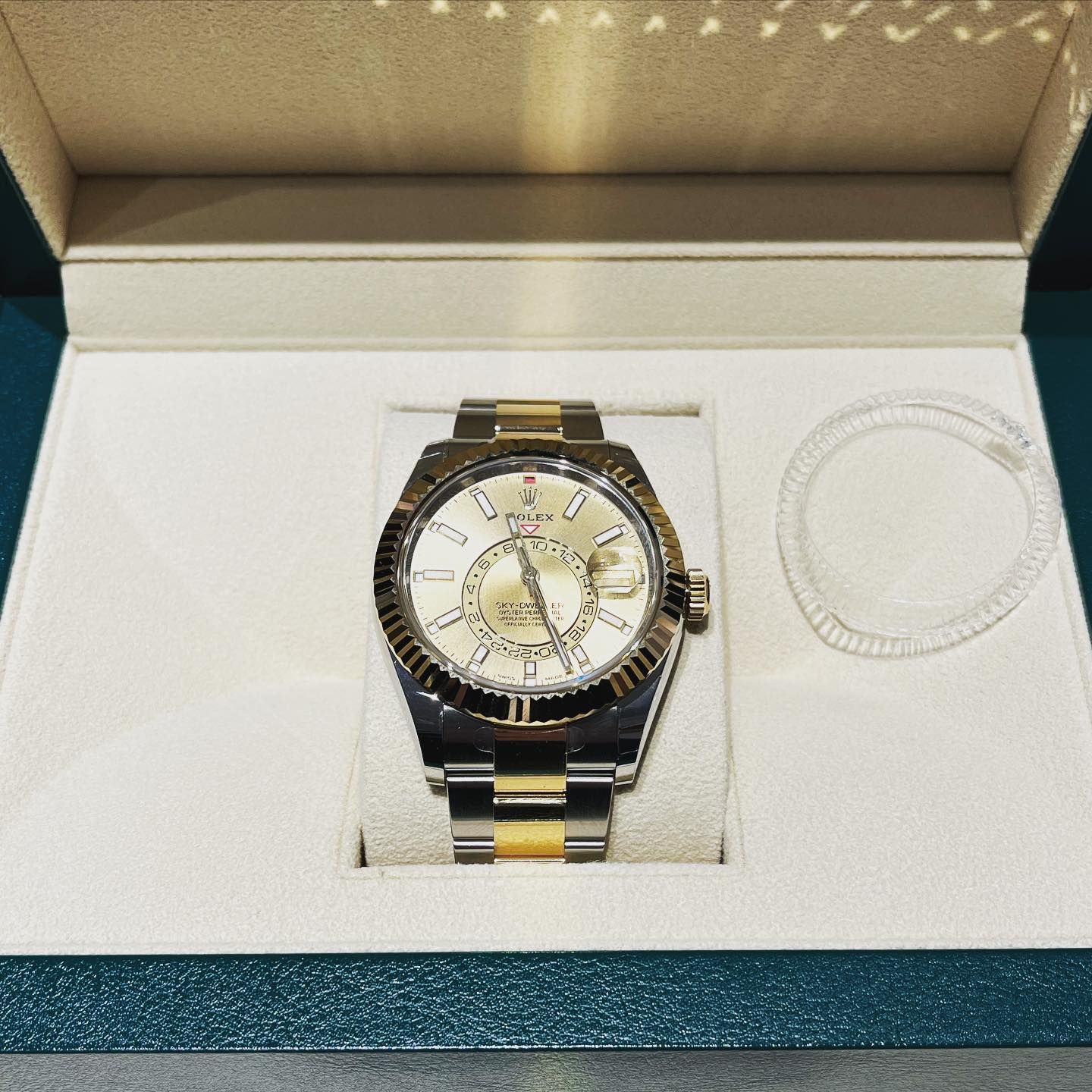 Luxury wristwatch in a presentation box with silver and gold band and white dial