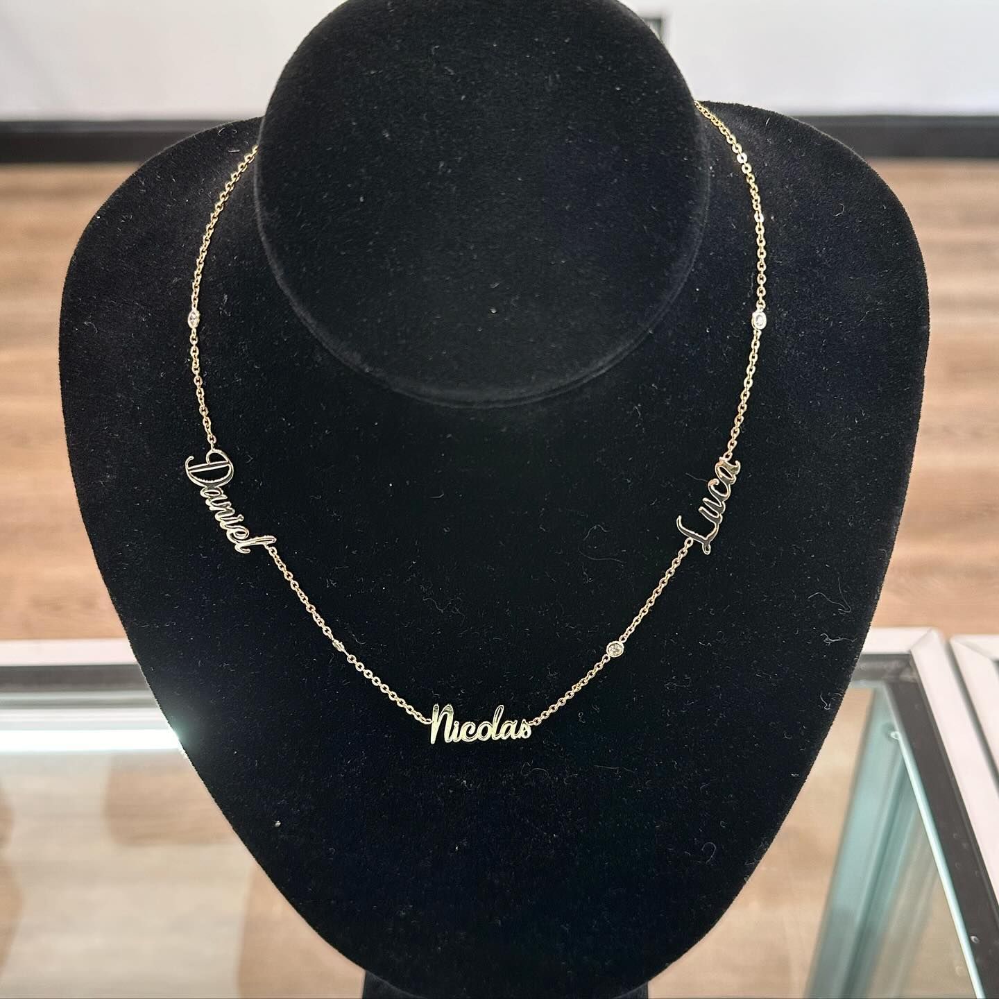 Gold necklace on a black display bust in a jewelry case