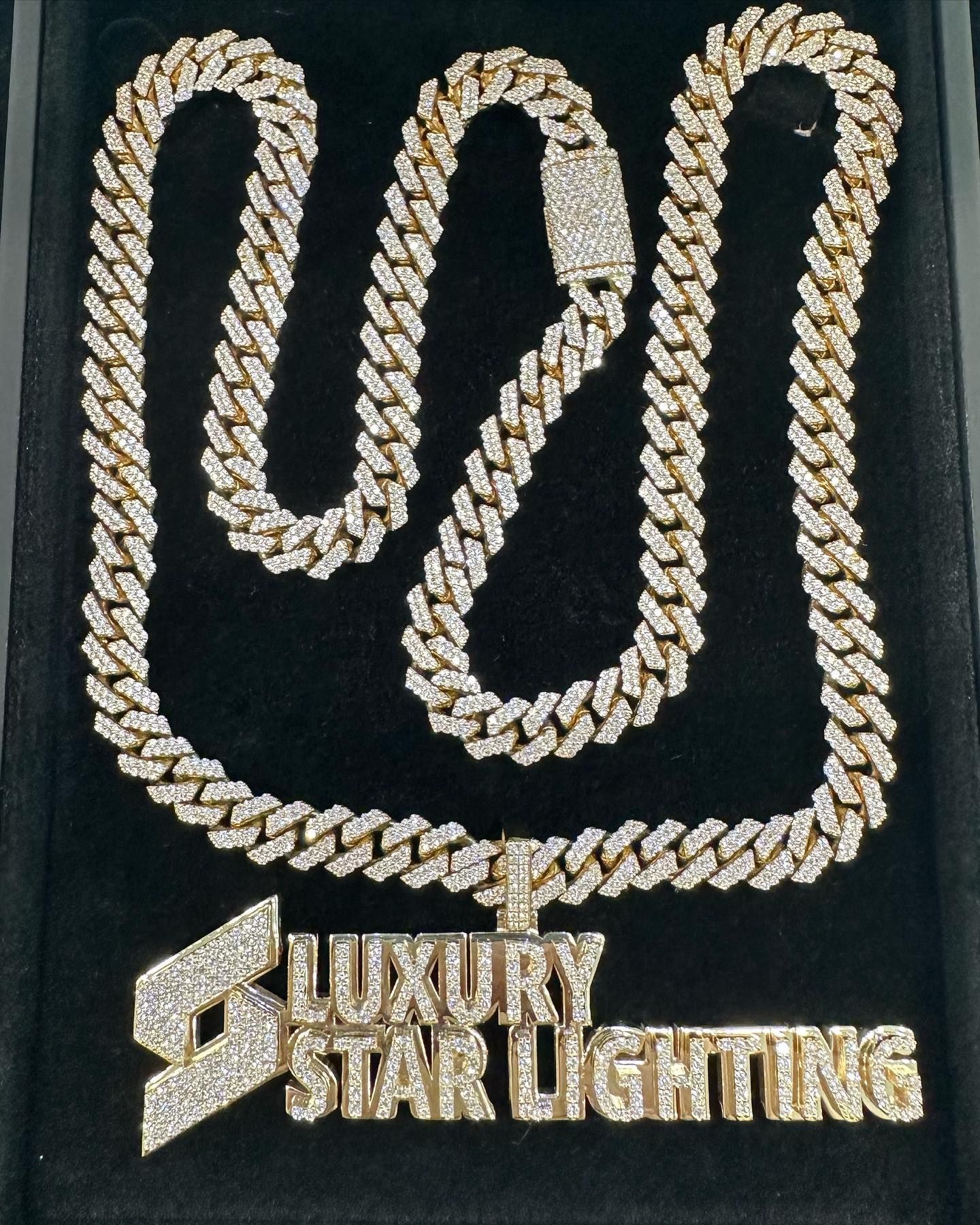 Gold Cuban link chain necklace on a black display box with “Luxury Star Lighting” logo