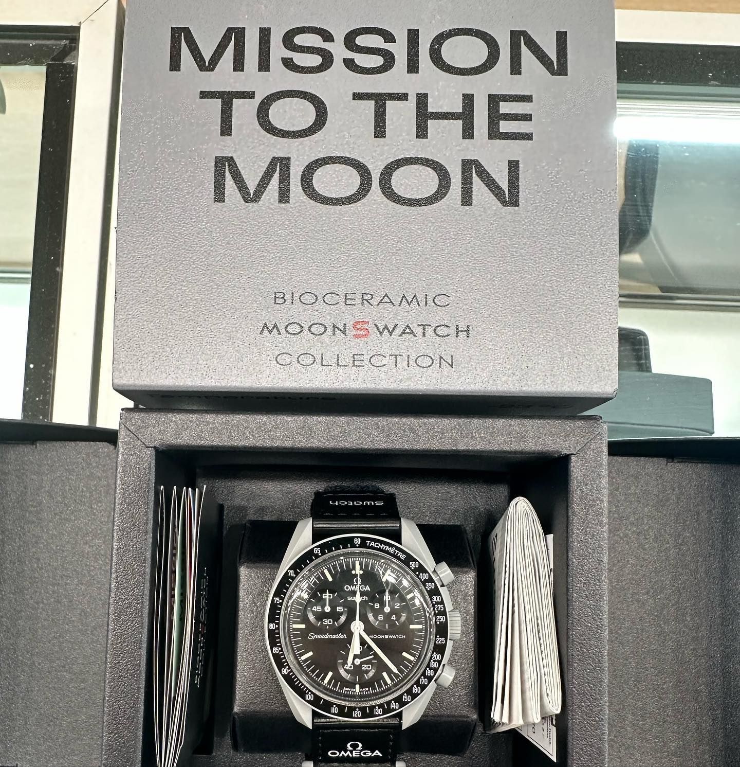 Mission to the Moon watch in an open black presentation box with gray packaging and a black strap