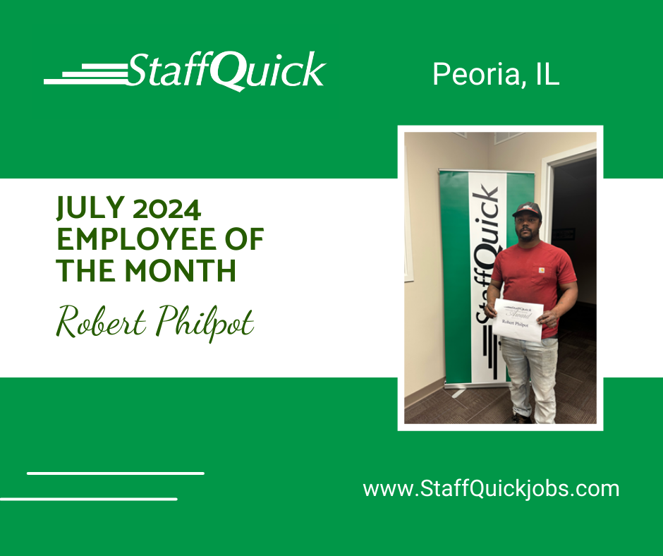 A man is holding a certificate in front of a sign that says staff quick