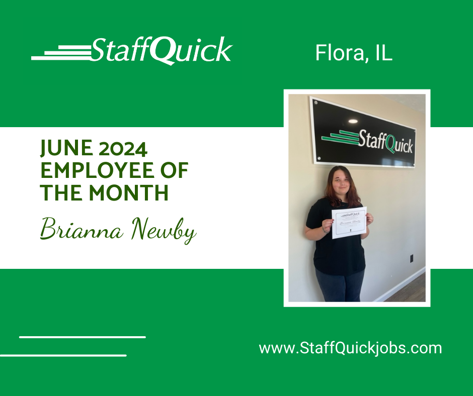A woman is standing in front of a wall holding a certificate.