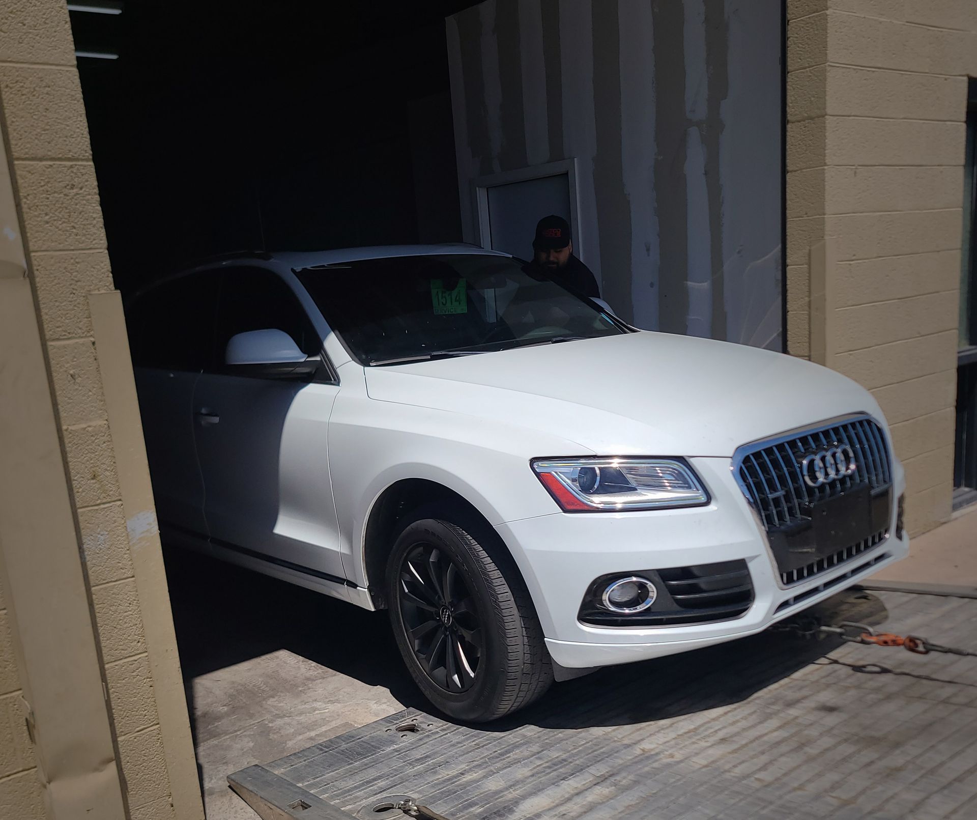 A white Audi car is parked in a garage