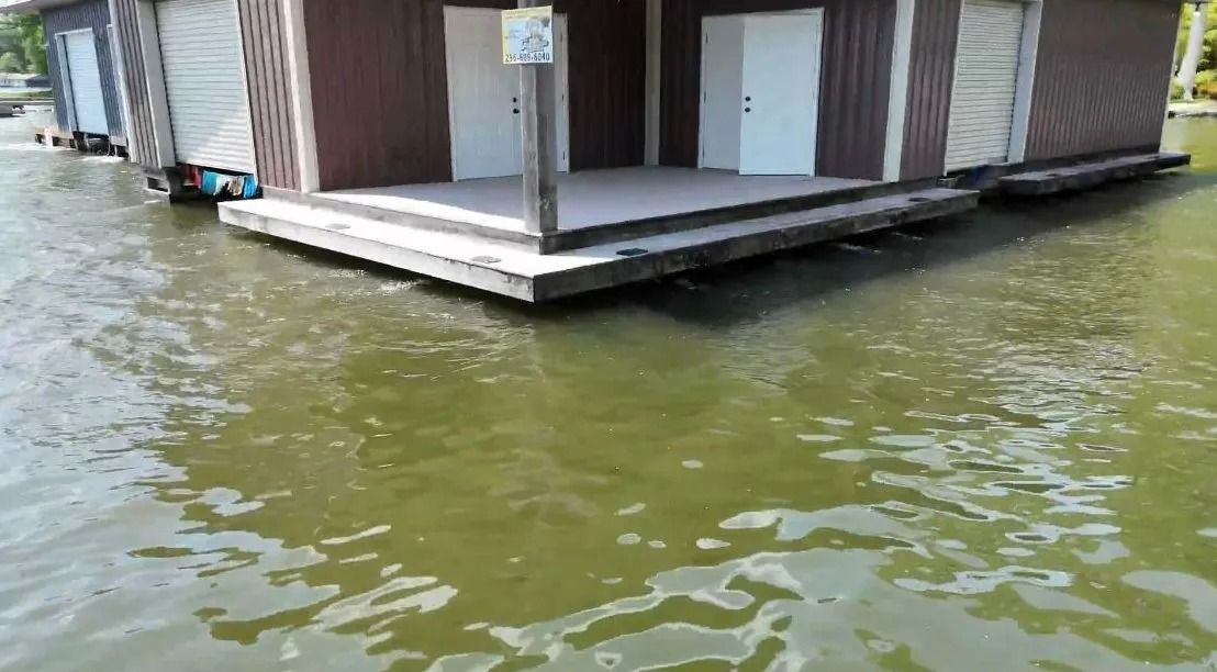 Floating dock with a small building above green water