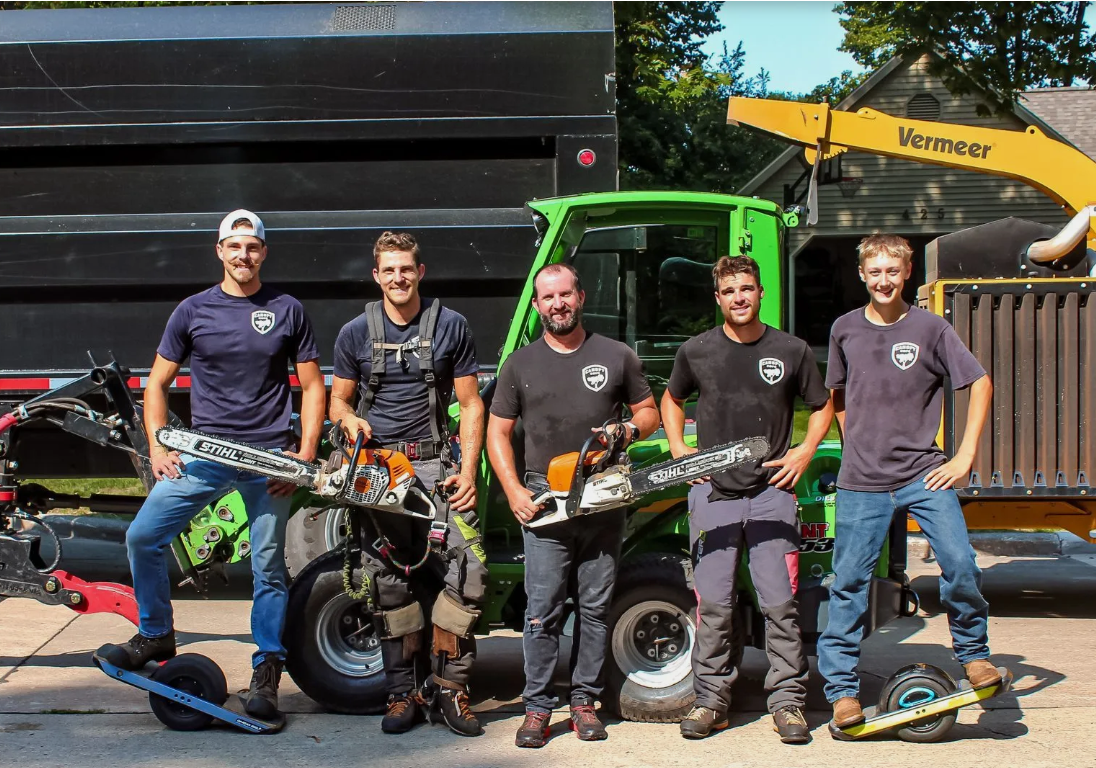 A group of men are posing for a picture in front of a truck.