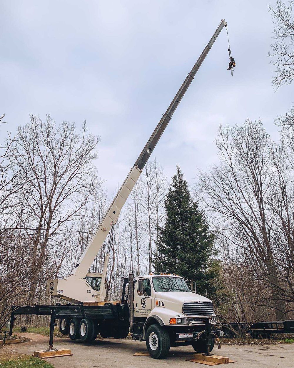 A truck with a crane attached to it is parked in a parking lot.
