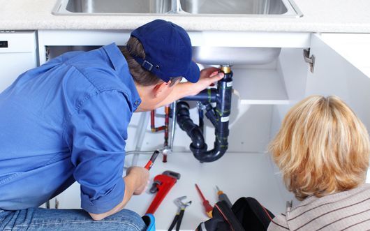 plumber looking at sink drain