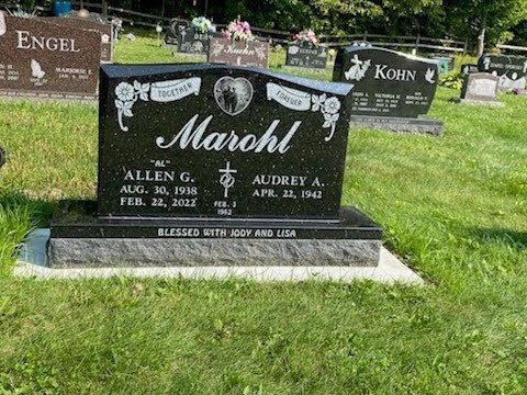 A black upright granite headstone for Allen G. and Audrey A. Marohl, inscribed with dates, set in a grassy cemetery.