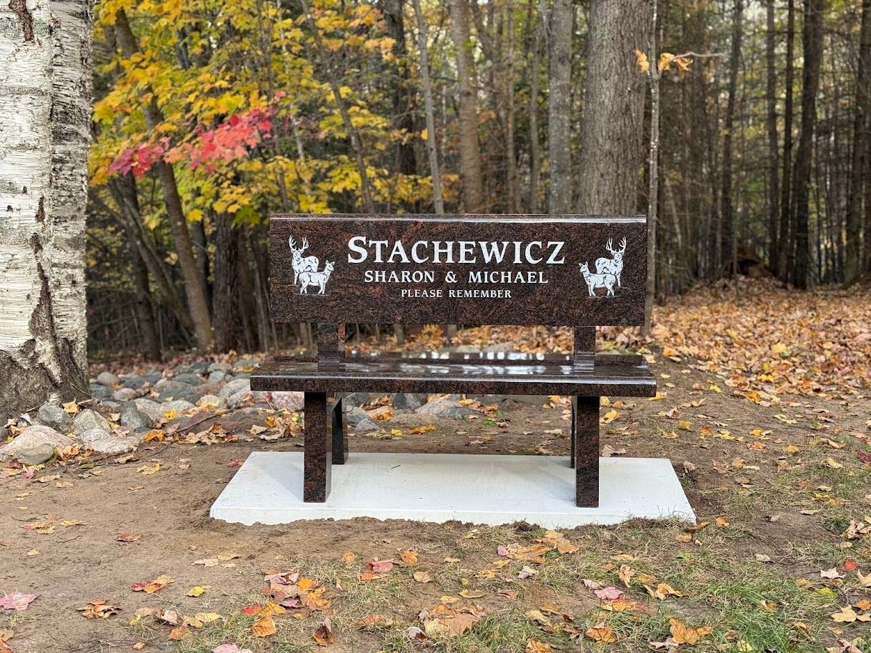 A polished granite memorial bench inscribed with 