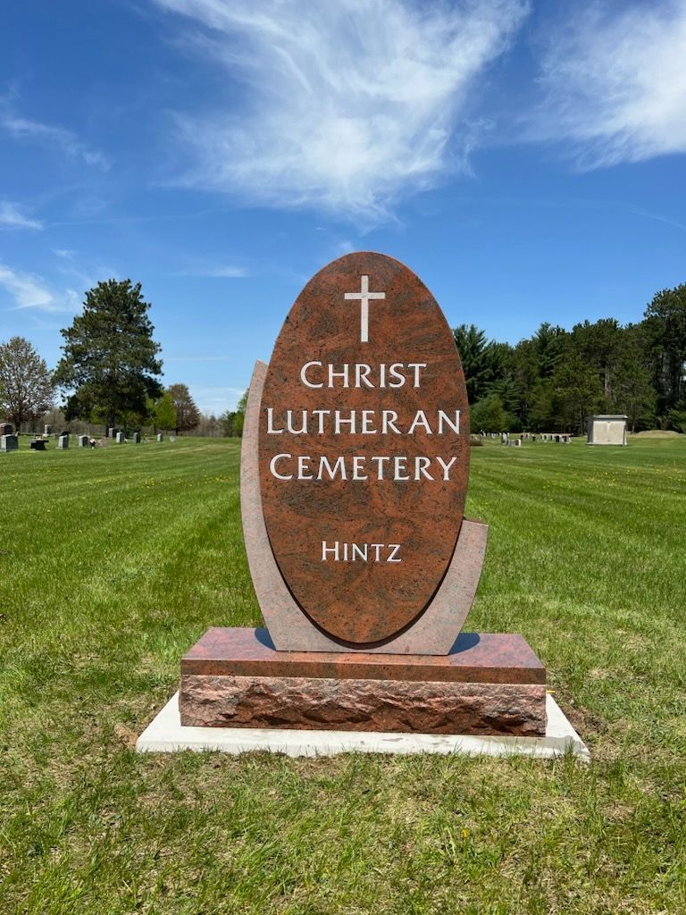 A red granite tombstone marked 