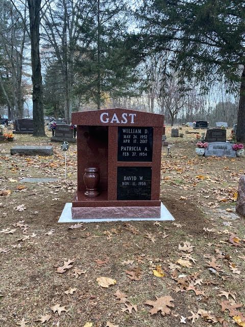 A red granite memorial headstone engraved with 
