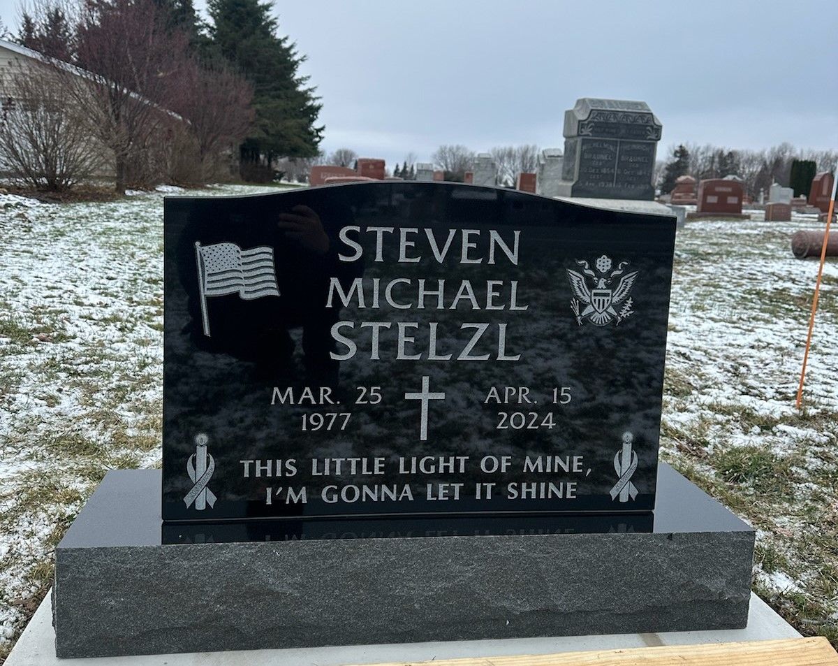 A gravestone in a snowy cemetery