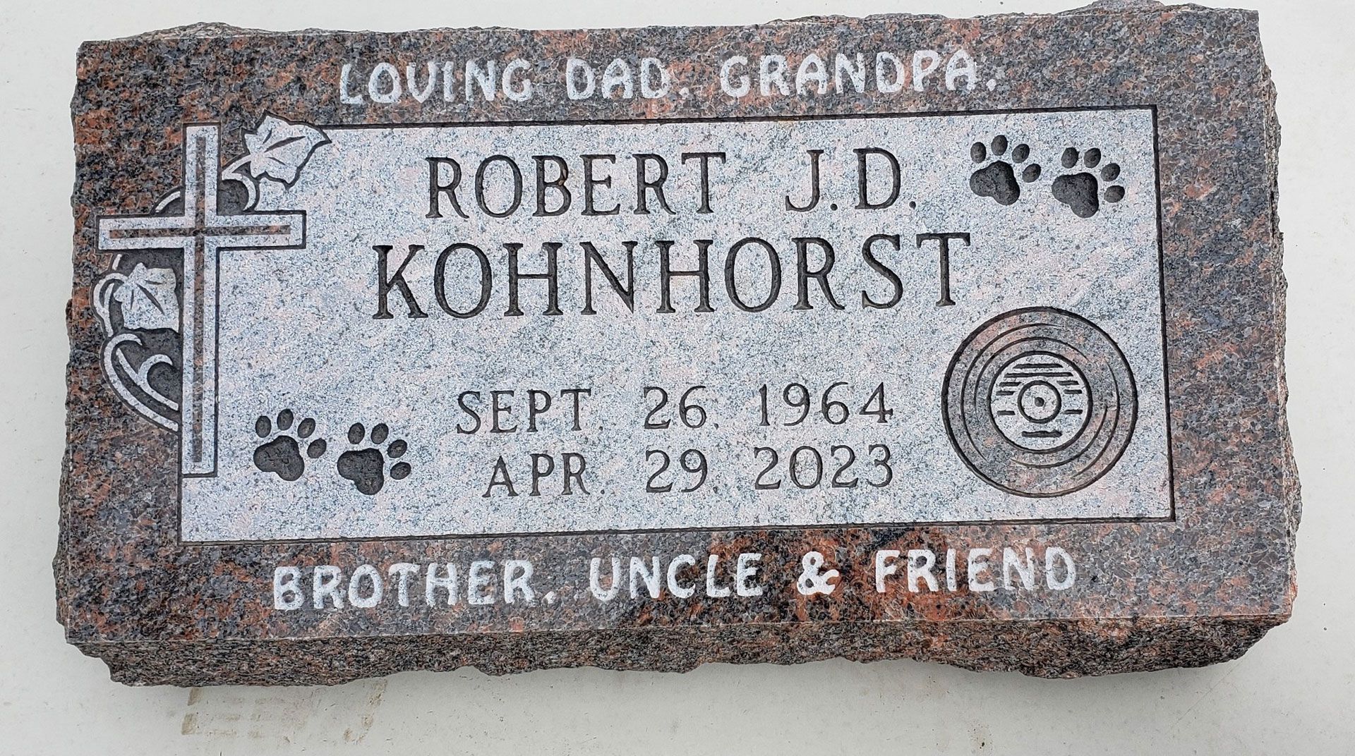 A gravestone with a cross and paw prints