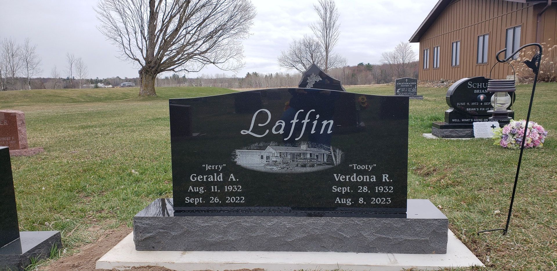 A black gravestone with the name daffin on it is in a cemetery.