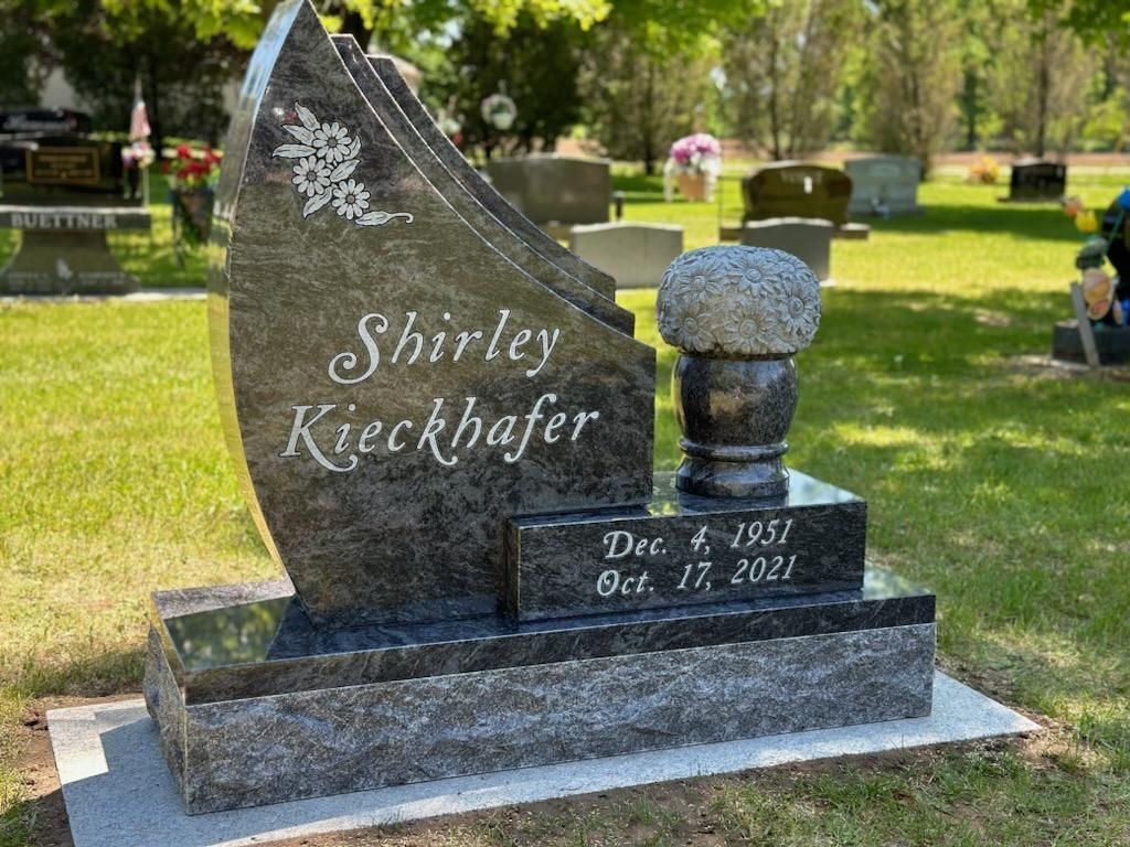 A gravestone for shirley kieckhofer is in a cemetery.