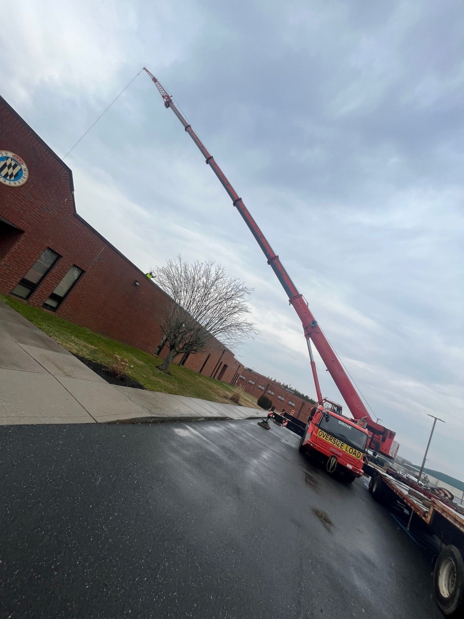 a large red crane is sitting on the side of the road in front of a building .