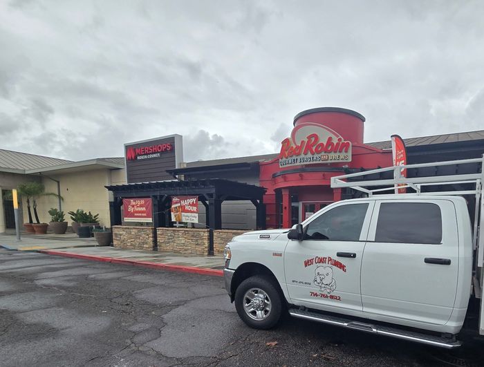 White pickup truck parked outside Robin restaurant with red awning on a cloudy day