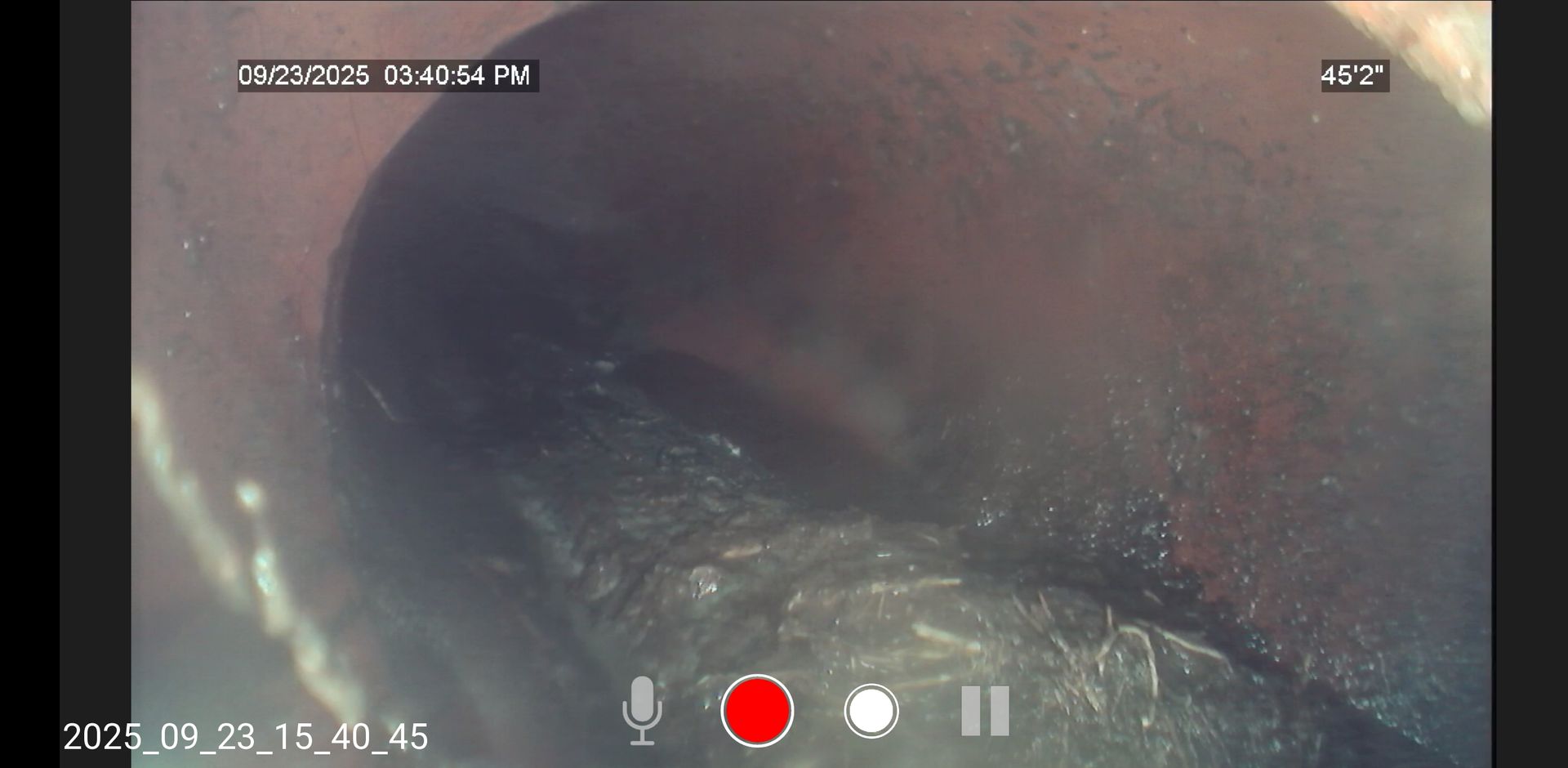 Close-up of a dark tunnel interior with a red recording button overlay on screen