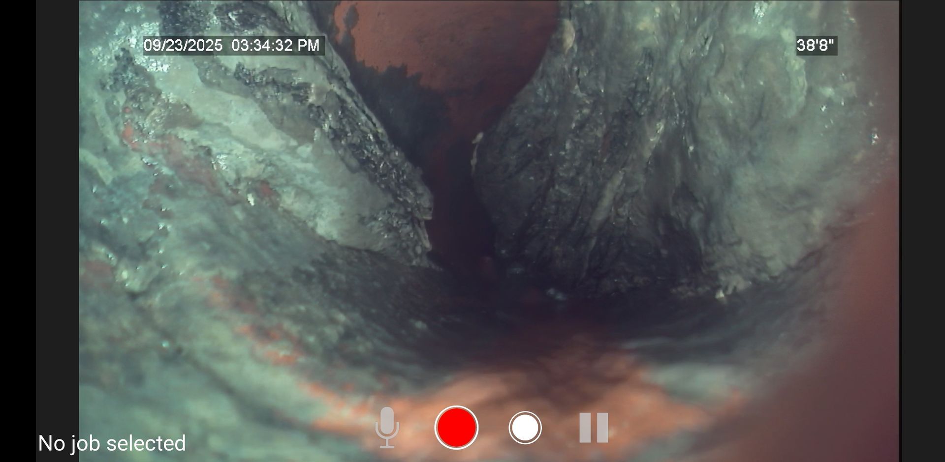 Inside a dark, narrow tunnel with murky green water and a red recording dot overlay