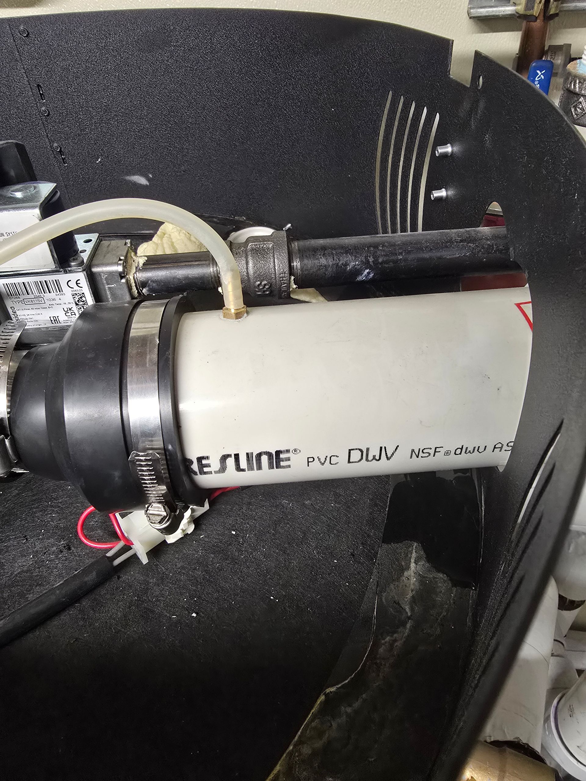 Close-up of a white cylindrical device with black tubing and cables inside a foam-lined compartment