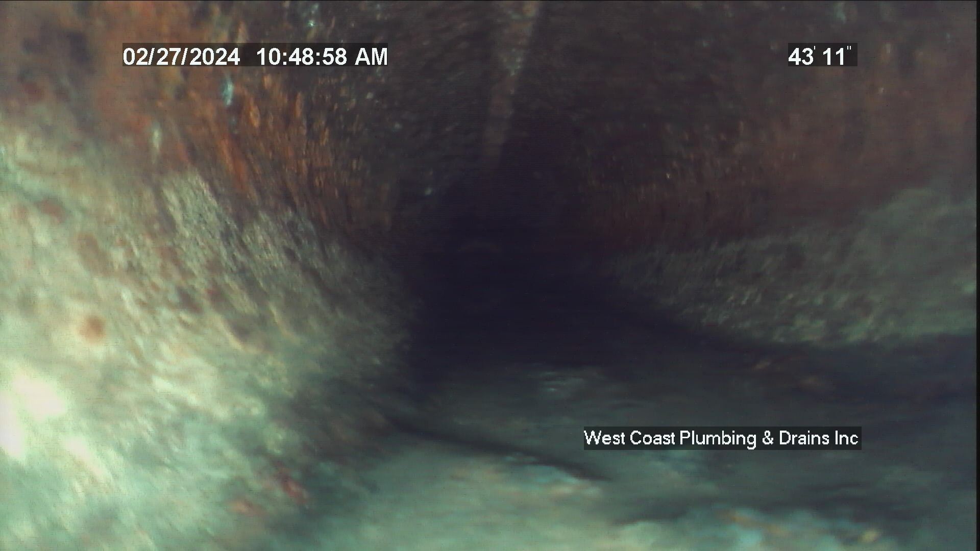 Blurred tunnel-like scene with greenish walls and a timestamp overlay on the video feed