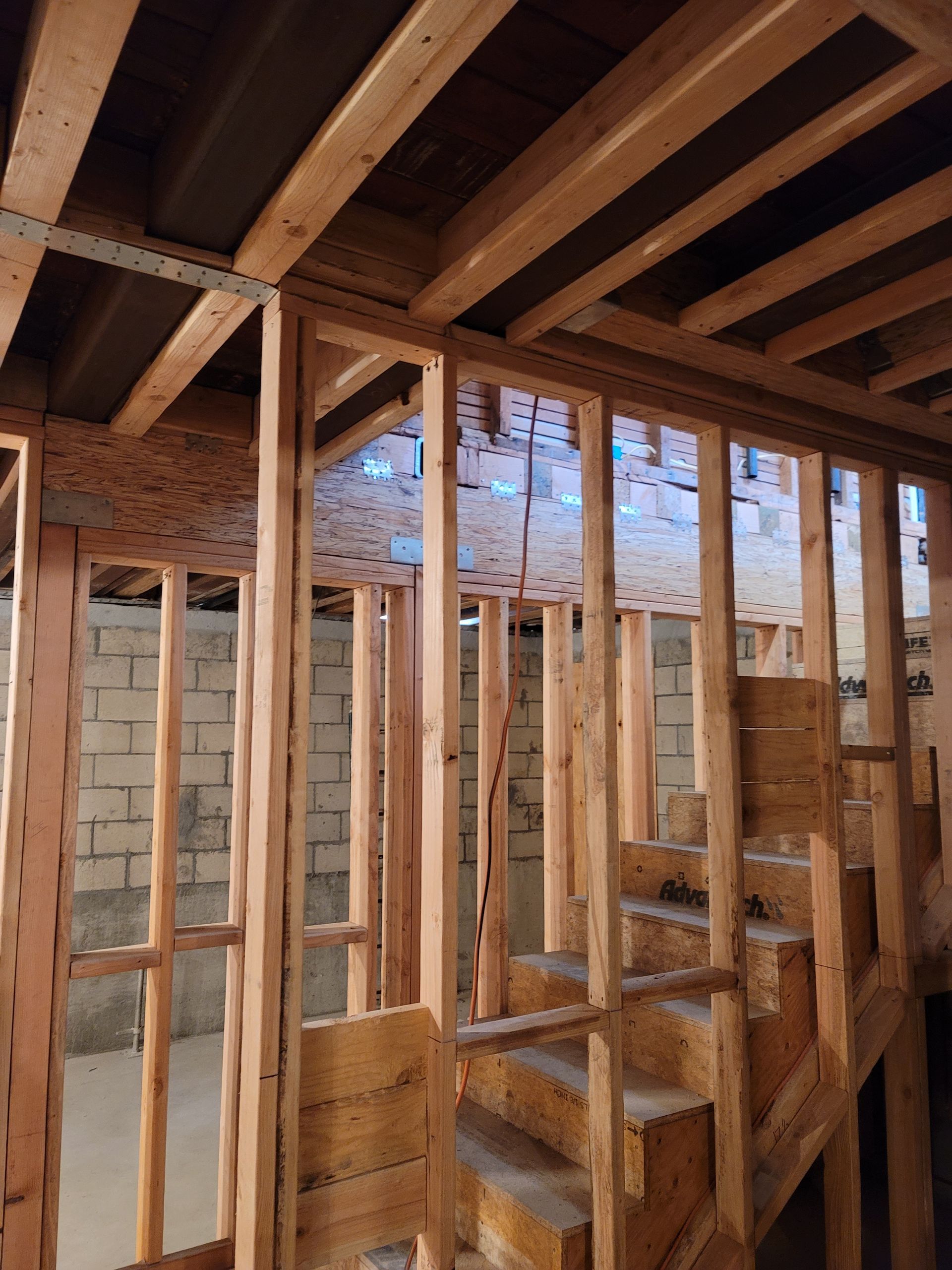 Interior of a house under construction with exposed wooden framing and roof beams