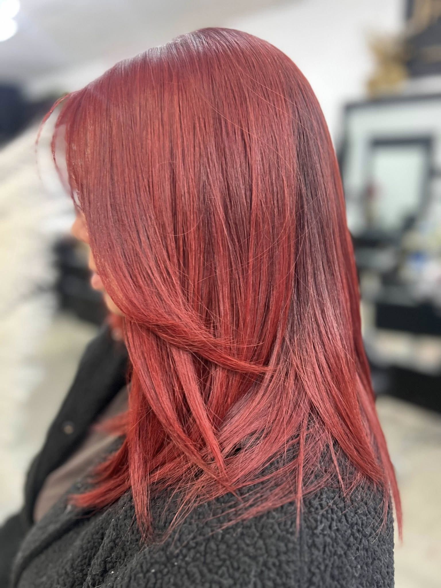 Woman with long, reddish hair in a salon setting.