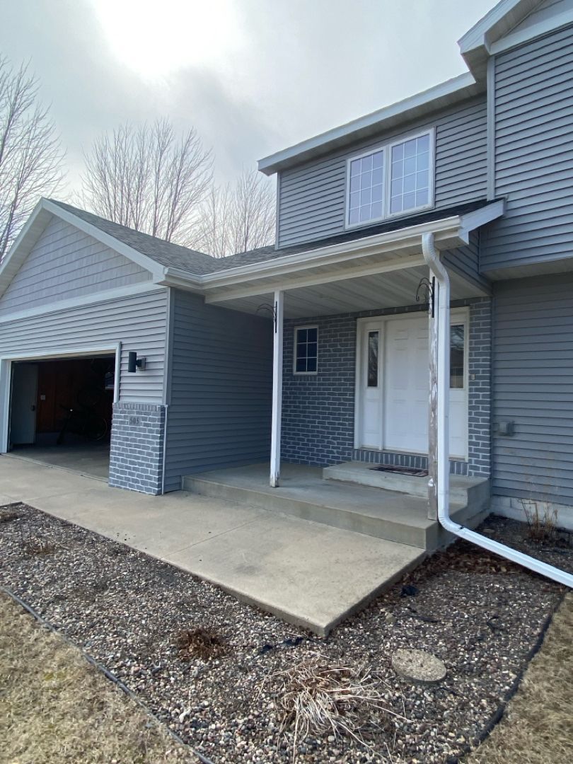 The front of a house with a porch and a garage.