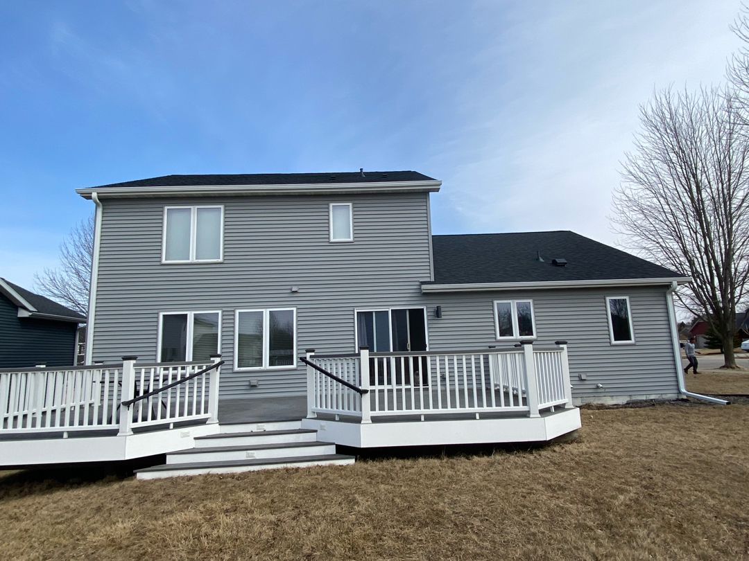 The back of a house with a large deck and stairs