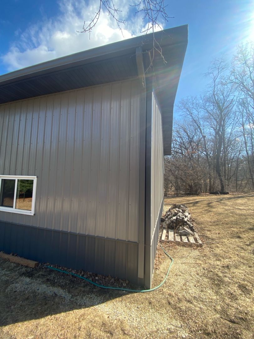 The side of a building with a window and a hose attached to it.