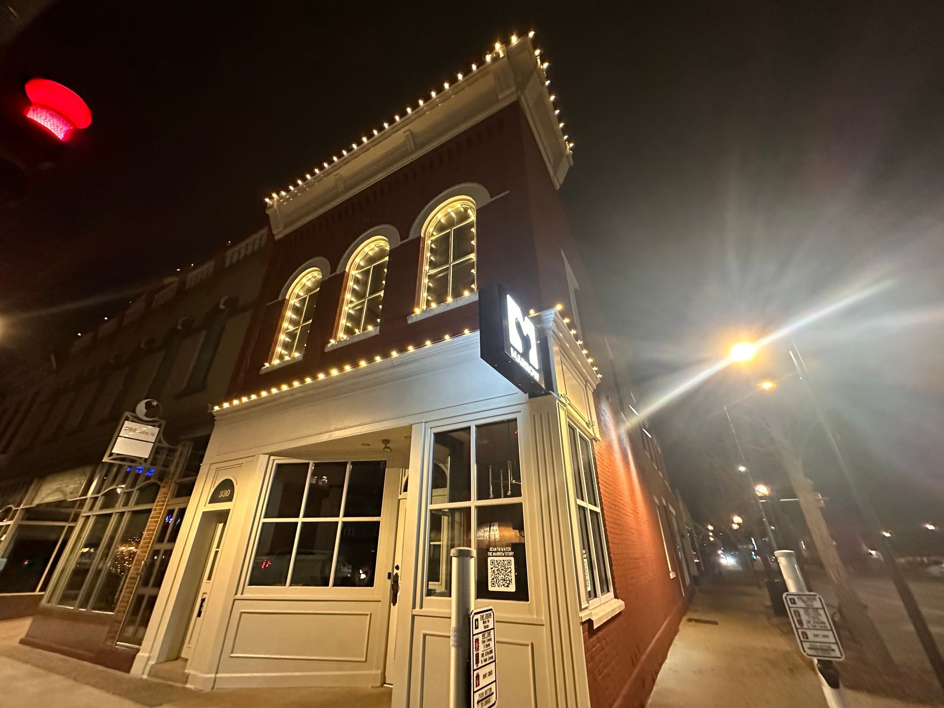 A building with Christmas lights on it is lit up at night.