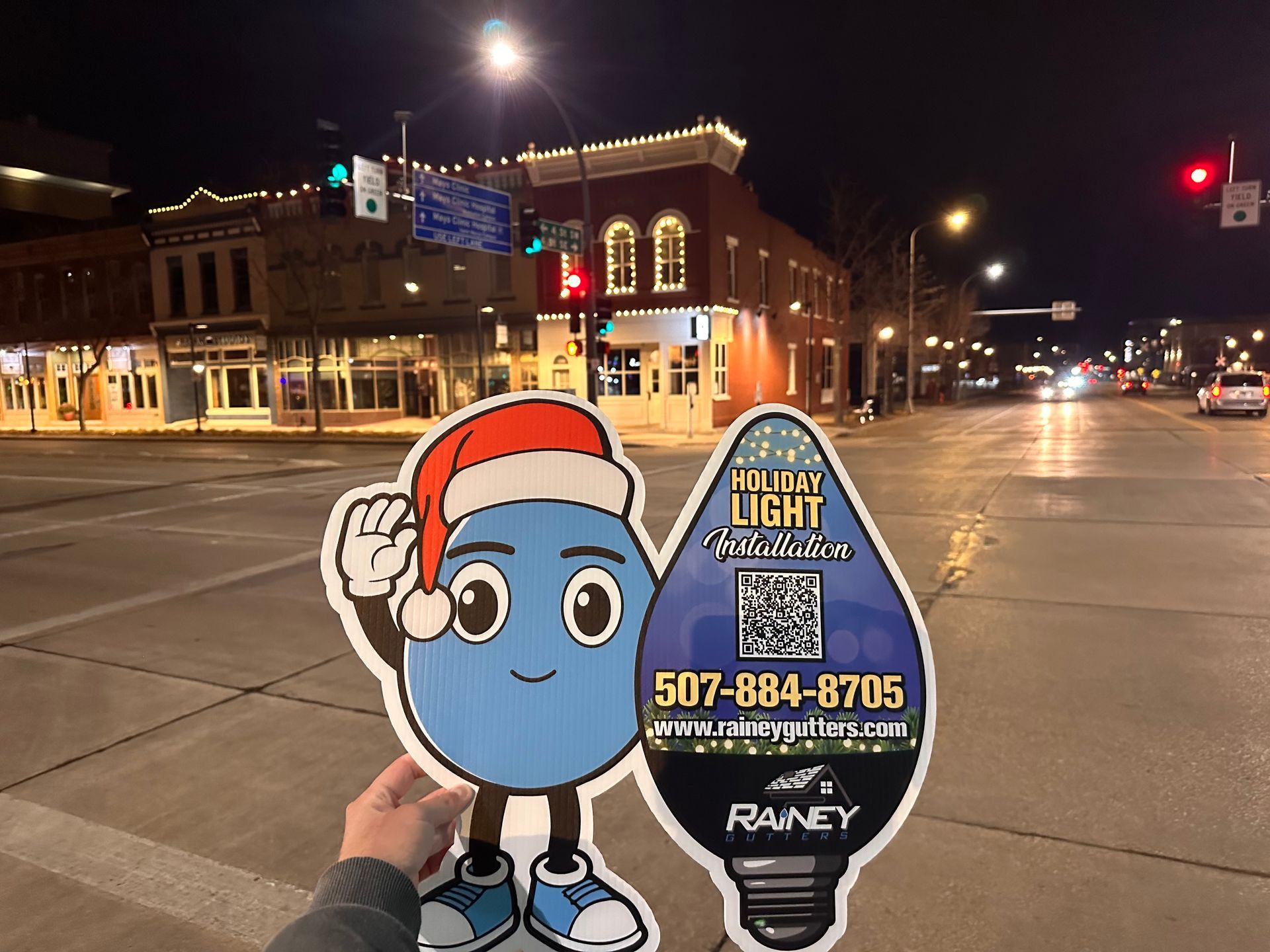 A person is holding a sign with a light bulb on it