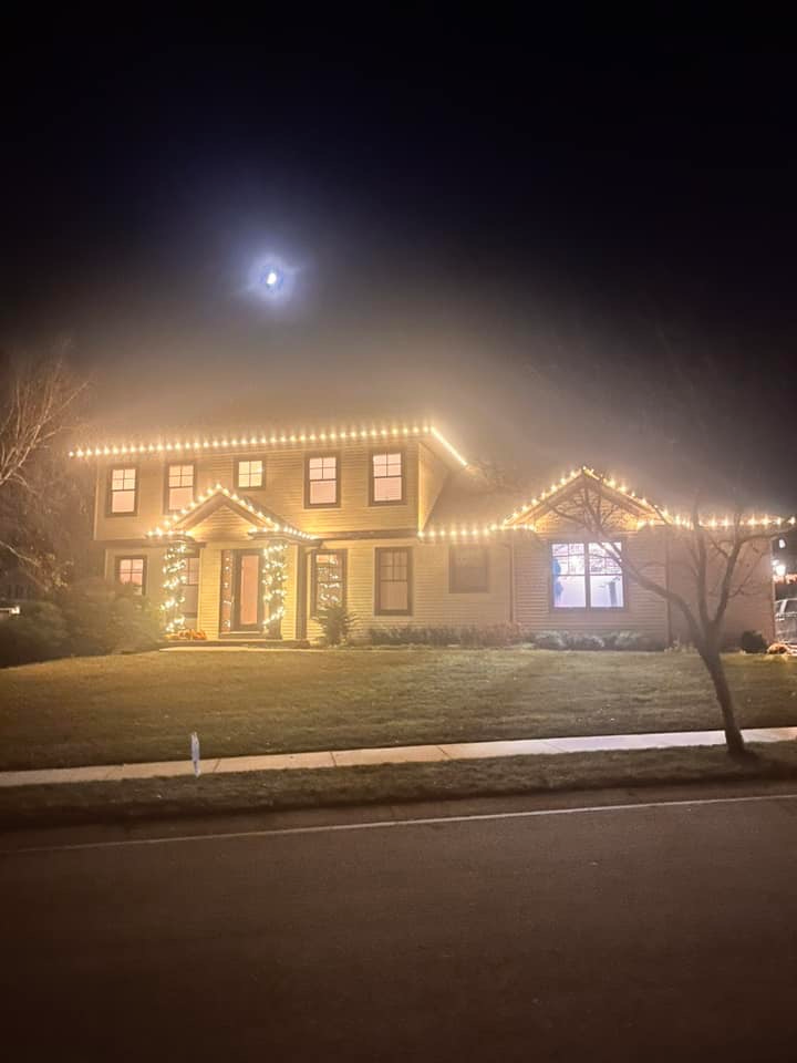A large house is lit up with Christmas lights at night.