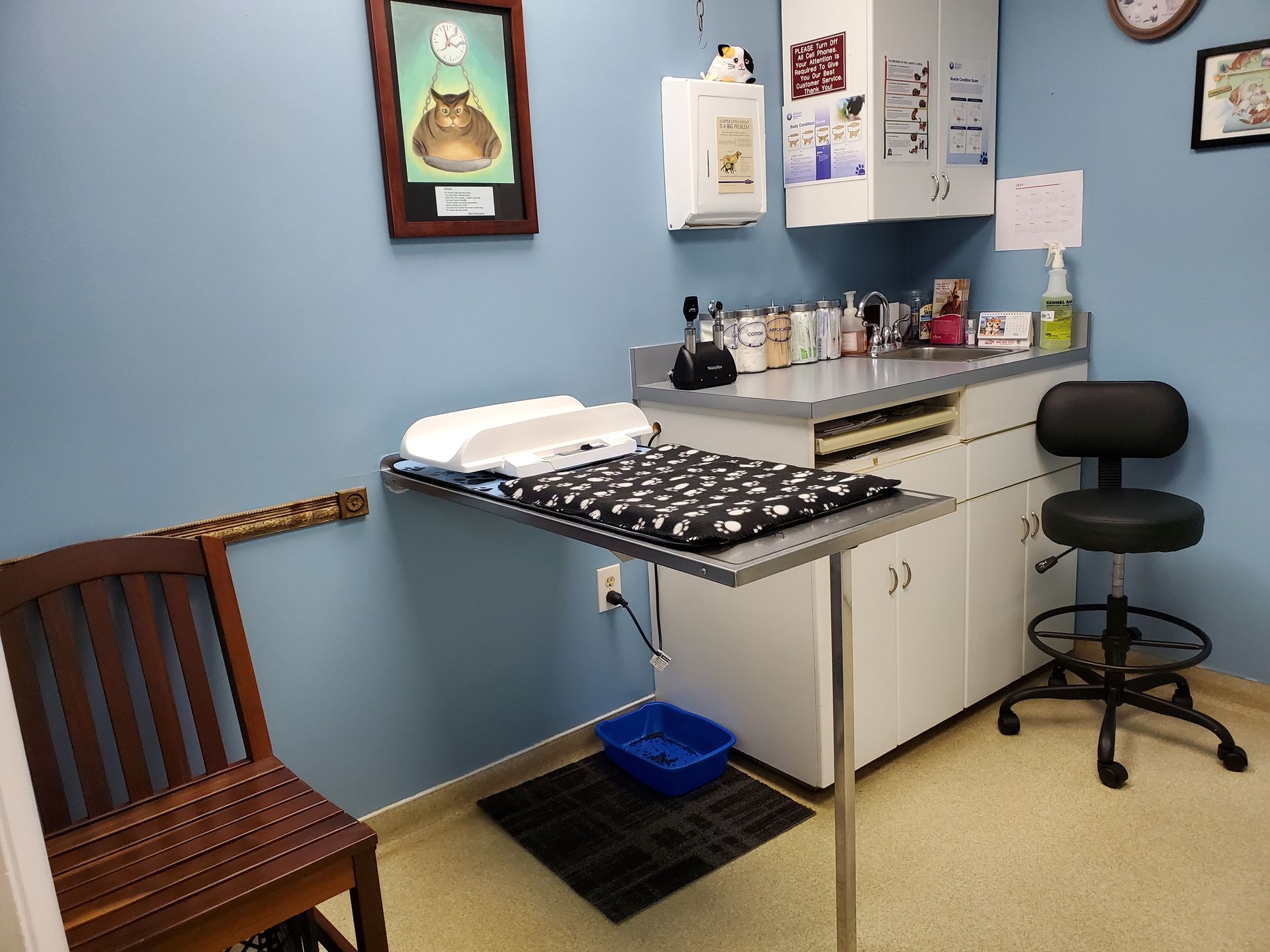 A veterinarian 's office with a table and a chair.