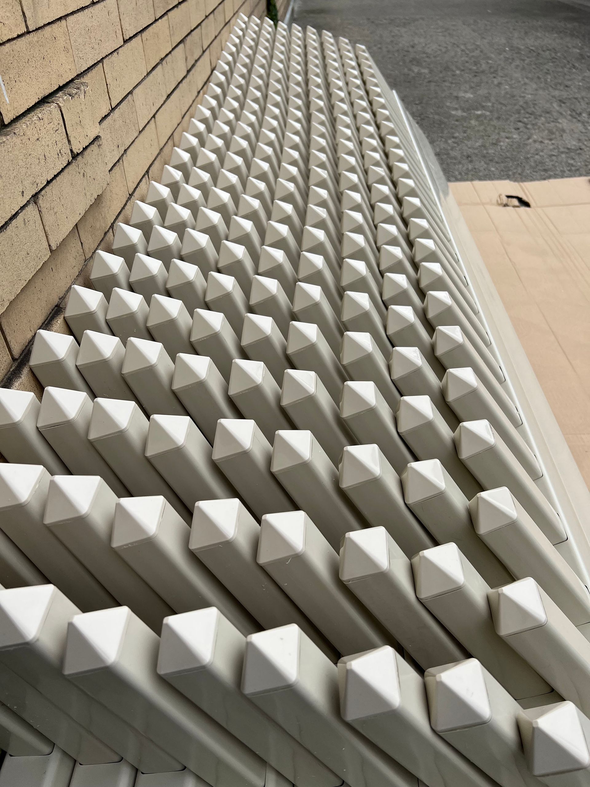 A stack of white triangles against a brick wall