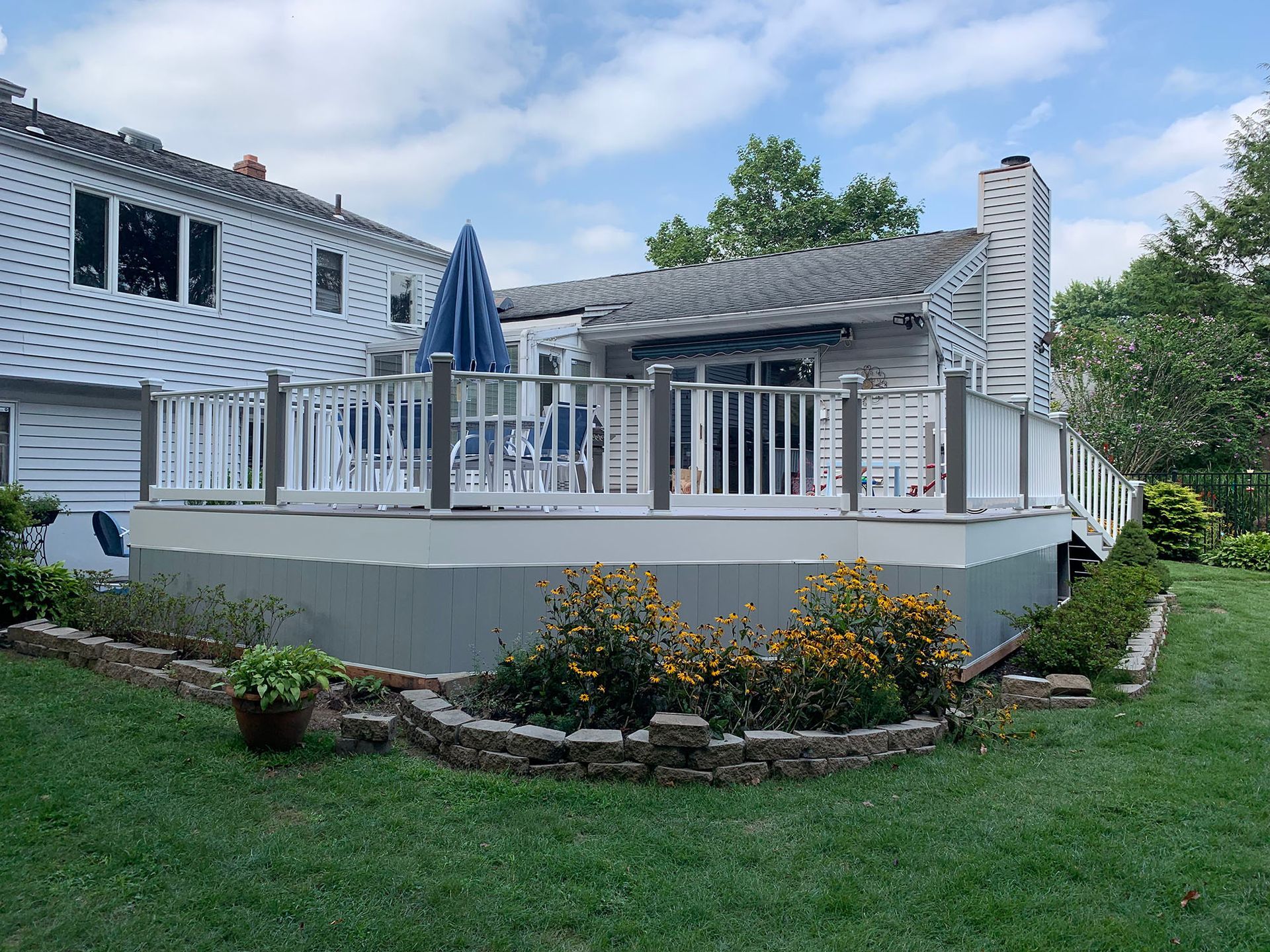 A large white house with a large deck in the backyard