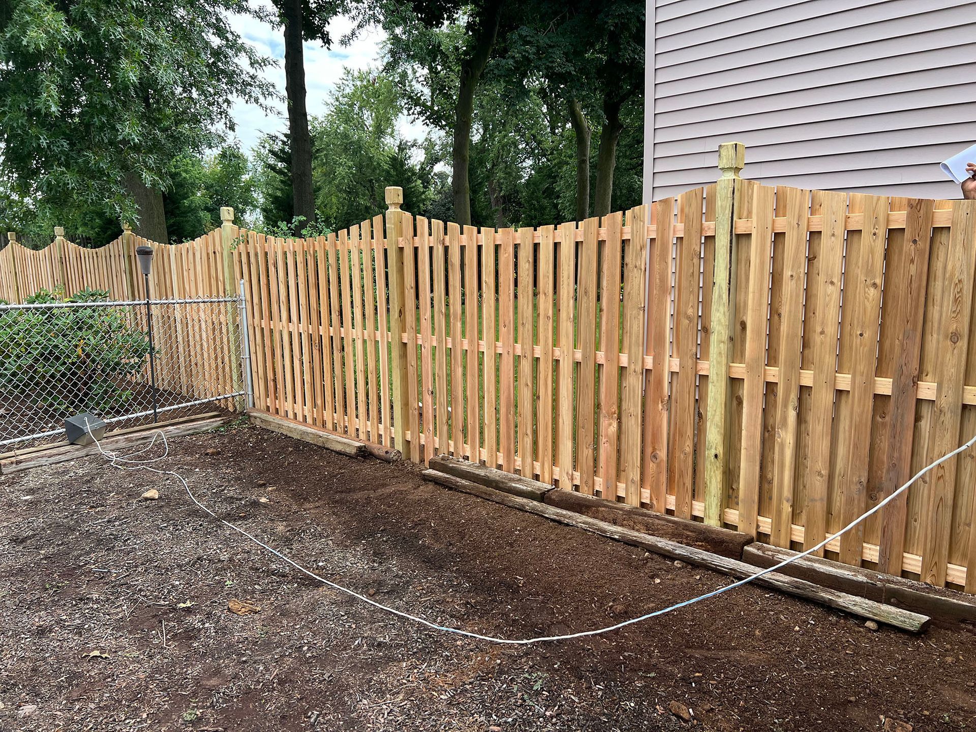 A wooden fence is being built in front of a house.